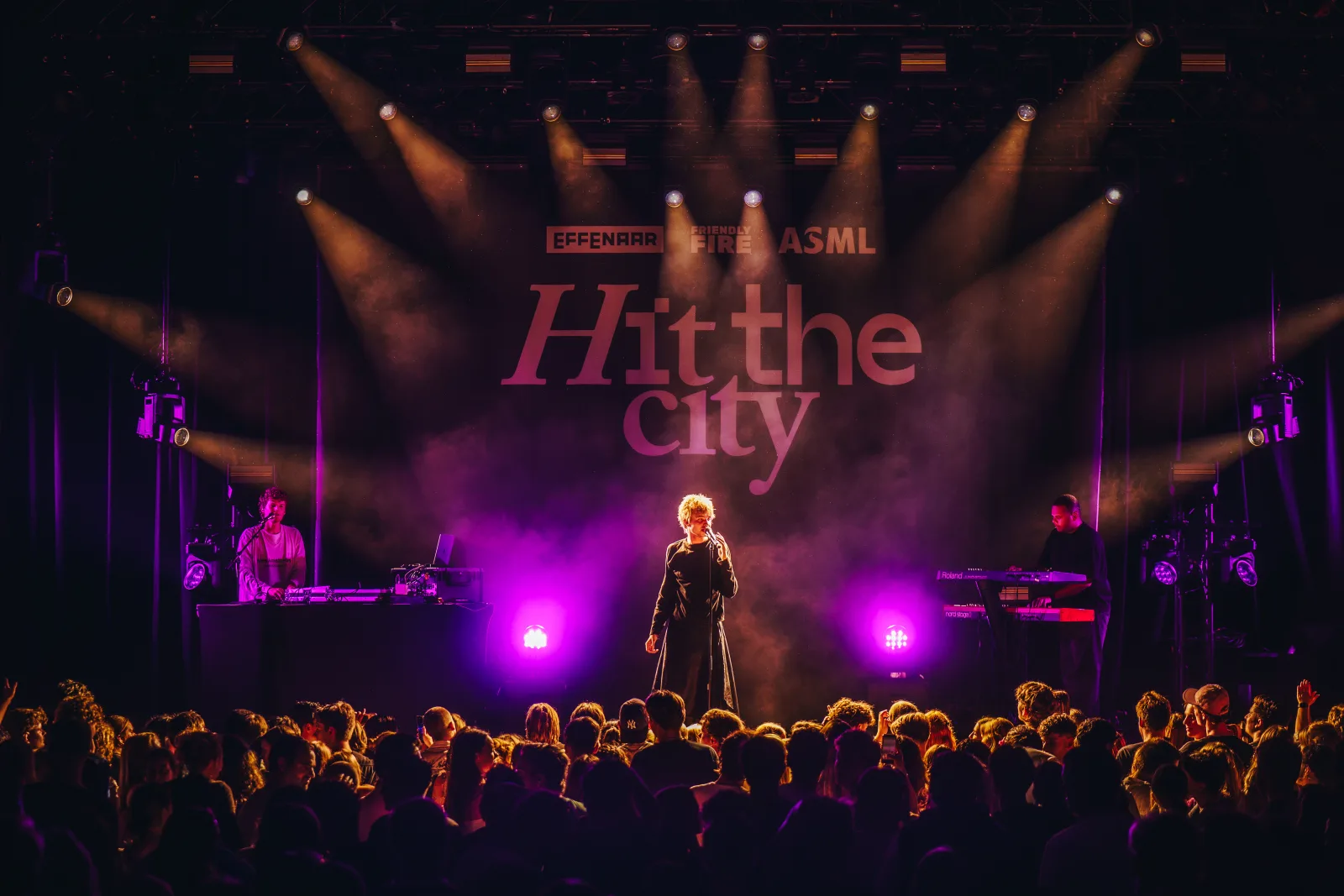 Jesse Hoefnagels performing live on stage at Effenaar for Hit the City, with band and lit crowd in purple stage light.
